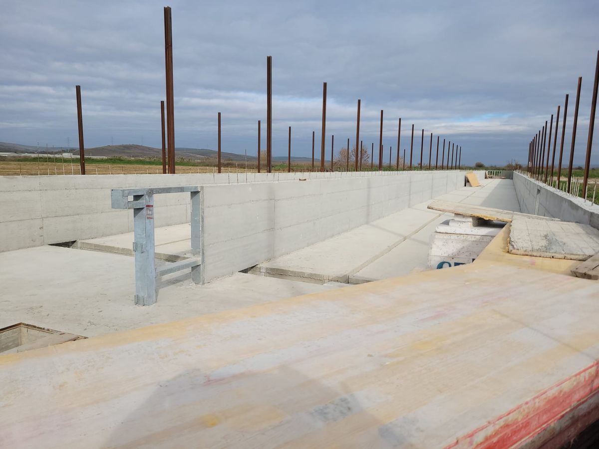 Placă de ancorare din oțel prinsă în fundația de beton a unei hale