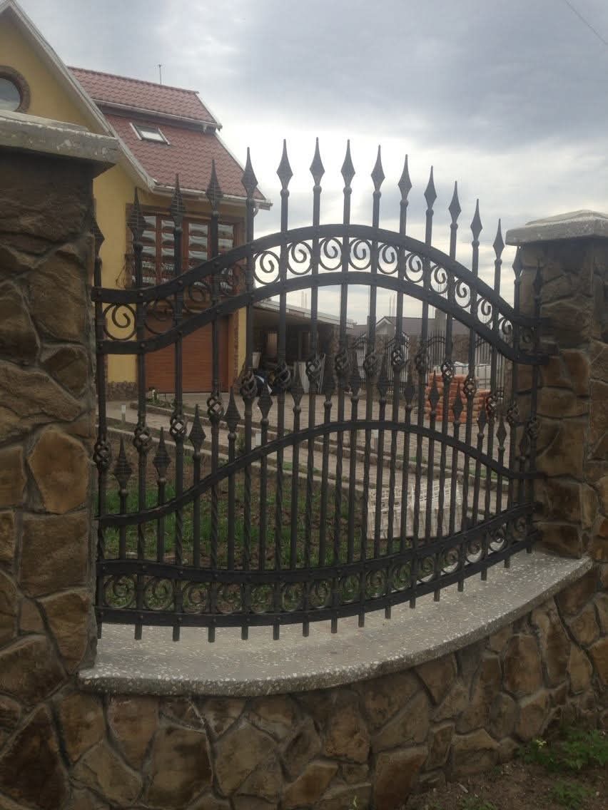 Împrejmuire metalică cu arcuri și suliți pe soclu de piatră, lucrare în Vaslui