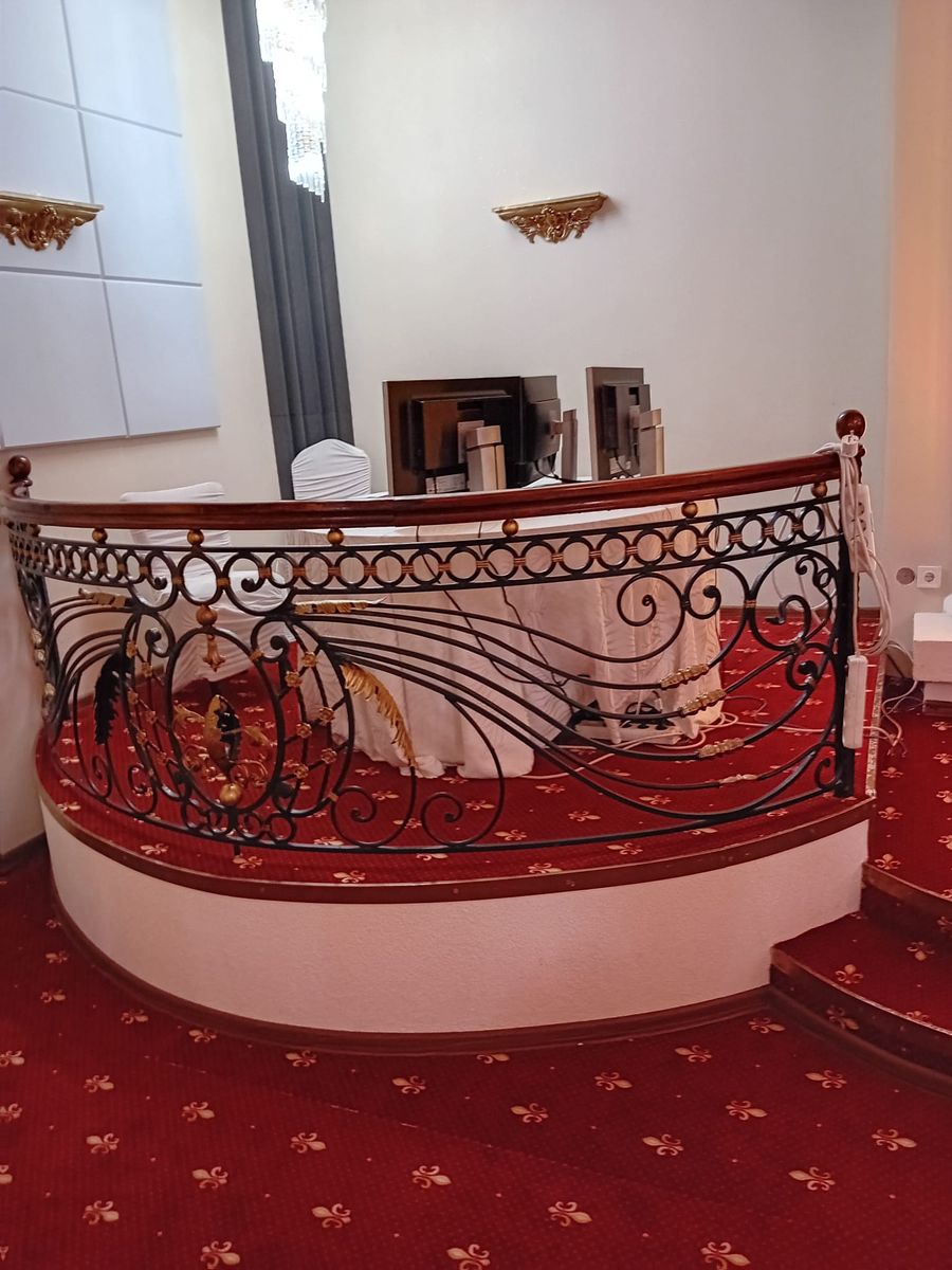 Balustradă semicirculară din fier forjat la un restaurant cu covor roșu