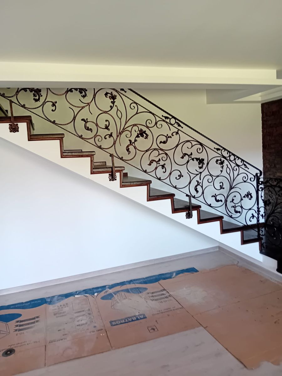Balustradă lungă din fier forjat cu frunze pe o scară interioară, după montaj