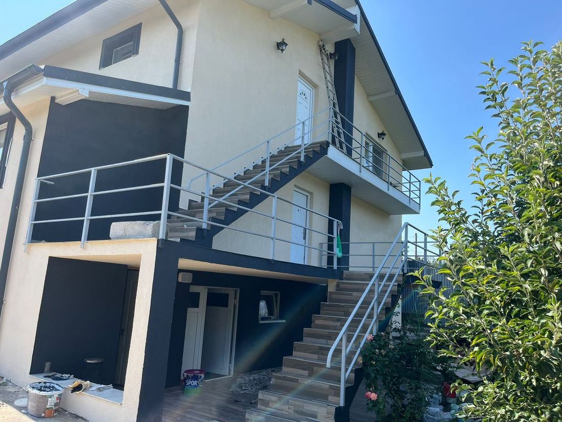 Balustrade metalice pe scările exterioare și balconul unei case cu etaj